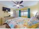 This bedroom has a ceiling fan, a mounted flat screen TV, and nice natural lighting at 4141 S Atlantic Ave # 605, New Smyrna Beach, FL 32169
