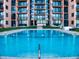 A sparkling blue pool sits in front of a modern building with multiple balconies, offering a luxurious outdoor space at 4141 S Atlantic Ave # 605, New Smyrna Beach, FL 32169