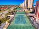 Aerial view of tennis courts and nearby streets and businesses, surrounded by trees and clear blue sky at 4141 S Atlantic Ave # 605, New Smyrna Beach, FL 32169
