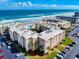 Aerial view of condominiums, parking, lush landscaping, and close beach access at 4175 S Atlantic Ave # 4110, New Smyrna Beach, FL 32169
