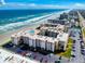 Aerial view of the condominium complex showing its proximity to the beach, pool, tennis court, and parking at 4175 S Atlantic Ave # 4110, New Smyrna Beach, FL 32169