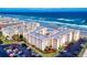 Stunning aerial view of beachfront condos, pool, sandy beach and parking area, offering coastal living at 4175 S Atlantic Ave # 4110, New Smyrna Beach, FL 32169