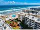 Aerial view featuring beachfront condos, swimming pool, green spaces, and ample parking at 4175 S Atlantic Ave # 4110, New Smyrna Beach, FL 32169