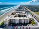 Wide aerial view of the condominium complex, highlighting beach access, tennis courts, and parking at 4175 S Atlantic Ave # 4110, New Smyrna Beach, FL 32169