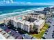 Beautiful aerial view of the condominium complex with ocean views, a pool, and a parking area at 4175 S Atlantic Ave # 4110, New Smyrna Beach, FL 32169