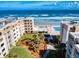 Aerial view featuring beachfront condos, a pool, lush landscaping and ocean views at 4175 S Atlantic Ave # 4110, New Smyrna Beach, FL 32169