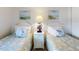Pair of twin beds with beach-themed bedding and decor creating a serene coastal atmosphere at 4175 S Atlantic Ave # 4110, New Smyrna Beach, FL 32169