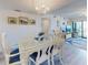 Bright dining area featuring a chandelier and seating for six with sliding door balcony access at 4175 S Atlantic Ave # 4110, New Smyrna Beach, FL 32169