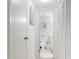 Hallway leading to bathroom with open door, featuring white walls and tile flooring at 4175 S Atlantic Ave # 4110, New Smyrna Beach, FL 32169