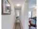 Hallway featuring wood floors, coastal-themed art, and access to the living room and bedroom at 4175 S Atlantic Ave # 4110, New Smyrna Beach, FL 32169