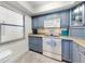 Kitchen featuring gray cabinetry, modern appliances, and a window for natural light at 4175 S Atlantic Ave # 4110, New Smyrna Beach, FL 32169