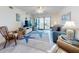 Comfortable living room with a large sofa, TV, and access to the balcony with ocean views at 4175 S Atlantic Ave # 4110, New Smyrna Beach, FL 32169