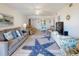 Comfortable living room with beach decor, a plush gray sofa, and a large starfish rug creating a coastal vibe at 4175 S Atlantic Ave # 4110, New Smyrna Beach, FL 32169