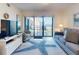 Cozy living room with a sofa, TV, and access to the balcony with ocean views at 4175 S Atlantic Ave # 4110, New Smyrna Beach, FL 32169