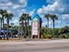 Ocean Village shopping center sign with list of businesses, surrounded by palm trees at 4175 S Atlantic Ave # 4110, New Smyrna Beach, FL 32169