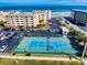 Tennis court aerial view showcasing proximity to condos, parking, and the beach at 4175 S Atlantic Ave # 4110, New Smyrna Beach, FL 32169