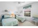 Charming bedroom with two twin beds, accented with floral bedding and natural light from the window at 438 Bouchelle Dr # 105, New Smyrna Beach, FL 32169