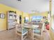 Bright dining area with glass table, wicker chairs and large window offering beautiful water views at 438 Bouchelle Dr # 105, New Smyrna Beach, FL 32169