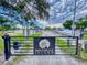 Gated entrance to Bouchelle Island with a sign, landscaping, and boat storage area in the background at 438 Bouchelle Dr # 105, New Smyrna Beach, FL 32169