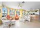 Bright, open living room with wicker furniture, tile flooring and expansive windows at 438 Bouchelle Dr # 105, New Smyrna Beach, FL 32169