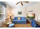Cozy living area features a comfortable blue sofa, a ceiling fan, and a television for relaxation at 438 Bouchelle Dr # 105, New Smyrna Beach, FL 32169