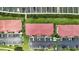 Detailed aerial view of condo complex, showing parking, landscaping, and red tile roof at 454 Bouchelle Dr # 102, New Smyrna Beach, FL 32169