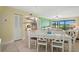 Bright dining area with white table and chairs, adjacent to a living space at 454 Bouchelle Dr # 102, New Smyrna Beach, FL 32169
