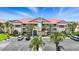 Beautiful multi-story condo complex with a red roof, lush landscaping, and ample parking at 454 Bouchelle Dr # 102, New Smyrna Beach, FL 32169