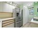 Well-lit kitchen features stainless steel refrigerator and white cabinetry at 454 Bouchelle Dr # 102, New Smyrna Beach, FL 32169