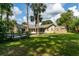 Spacious backyard view with a well-maintained lawn, mature trees, and a charming storage shed at 4623 Secret River Trl, Port Orange, FL 32129