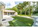 Lush backyard featuring a well-maintained artificial lawn, screened patio, and inviting deck perfect for outdoor enjoyment at 4623 Secret River Trl, Port Orange, FL 32129