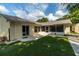 Spacious backyard with artificial turf, screened porch, and a view of the home's exterior, perfect for outdoor living at 4623 Secret River Trl, Port Orange, FL 32129