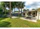 Expansive backyard featuring a patio, lush lawn, and mature palm trees, perfect for outdoor living at 4623 Secret River Trl, Port Orange, FL 32129