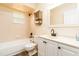 Cozy bathroom with white vanity and decorative mirror complementing the coordinated neutral tiled shower and flooring at 4623 Secret River Trl, Port Orange, FL 32129