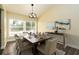 Elegantly staged dining room with contemporary lighting, seating for six, and a large window at 4623 Secret River Trl, Port Orange, FL 32129