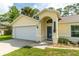 Home exterior featuring an attached garage, covered entryway, and well-kept lawn at 4623 Secret River Trl, Port Orange, FL 32129