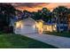 Beautiful home exterior illuminated at twilight, showcasing the garage, landscape, and elegant facade at 4623 Secret River Trl, Port Orange, FL 32129
