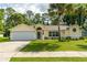 Charming single-story home featuring a well-manicured lawn, attached garage, and inviting front entrance at 4623 Secret River Trl, Port Orange, FL 32129