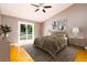 Inviting main bedroom features wood floors, a ceiling fan, and a sliding glass door at 4623 Secret River Trl, Port Orange, FL 32129
