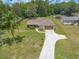 Aerial view of a charming single-Gathering home with a long driveway and a well-manicured front lawn at 5060 Audubon Ave, De Leon Springs, FL 32130