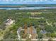 A broad aerial view shows the house in its surroundings with lakes and green areas in the distance at 5060 Audubon Ave, De Leon Springs, FL 32130