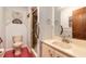 Cozy bathroom featuring a shower, toilet, vanity sink with a decorative lace window curtain at 5060 Audubon Ave, De Leon Springs, FL 32130