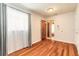 Bright bedroom featuring hardwood floors and natural light from a large window with sheer curtains at 5060 Audubon Ave, De Leon Springs, FL 32130