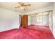 Spacious bedroom with fan, sliding mirror closet, and a view into another room at 5060 Audubon Ave, De Leon Springs, FL 32130