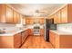 Well lit kitchen with stainless steel appliances, wooden cabinets and laminate flooring at 5060 Audubon Ave, De Leon Springs, FL 32130