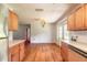 Bright kitchen featuring laminate floors and wooden cabinets, leading to backyard access at 5060 Audubon Ave, De Leon Springs, FL 32130