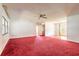 Large living room area with red carpet, ceiling fan, and great natural light at 5060 Audubon Ave, De Leon Springs, FL 32130