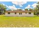 The back of the house includes windows and double doors, set against a backdrop of verdant grass at 5060 Audubon Ave, De Leon Springs, FL 32130