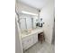 Well-lit bathroom with a long vanity, an integrated sink, and decorated with wallpaper at 51 Fore Dr, New Smyrna Beach, FL 32168