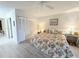 Bright bedroom featuring a bed with floral bedding, a ceiling fan, and plenty of closet space at 51 Fore Dr, New Smyrna Beach, FL 32168